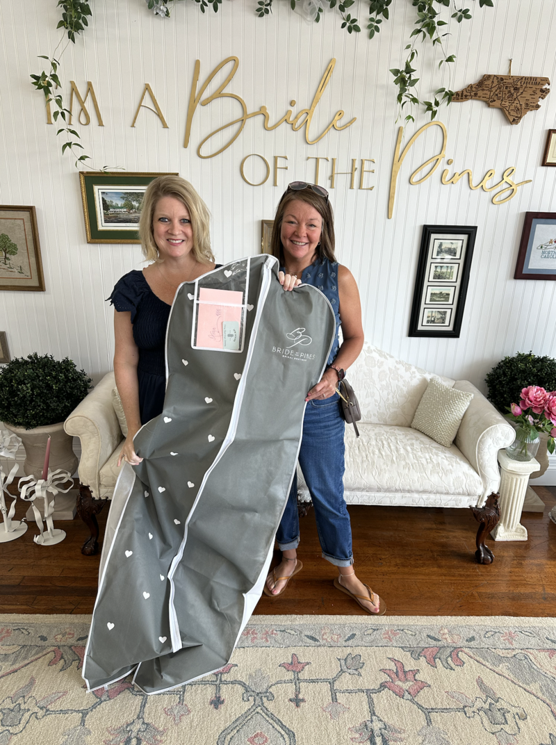 bride and her friend taking home her dream wedding gown from bride of the pines.