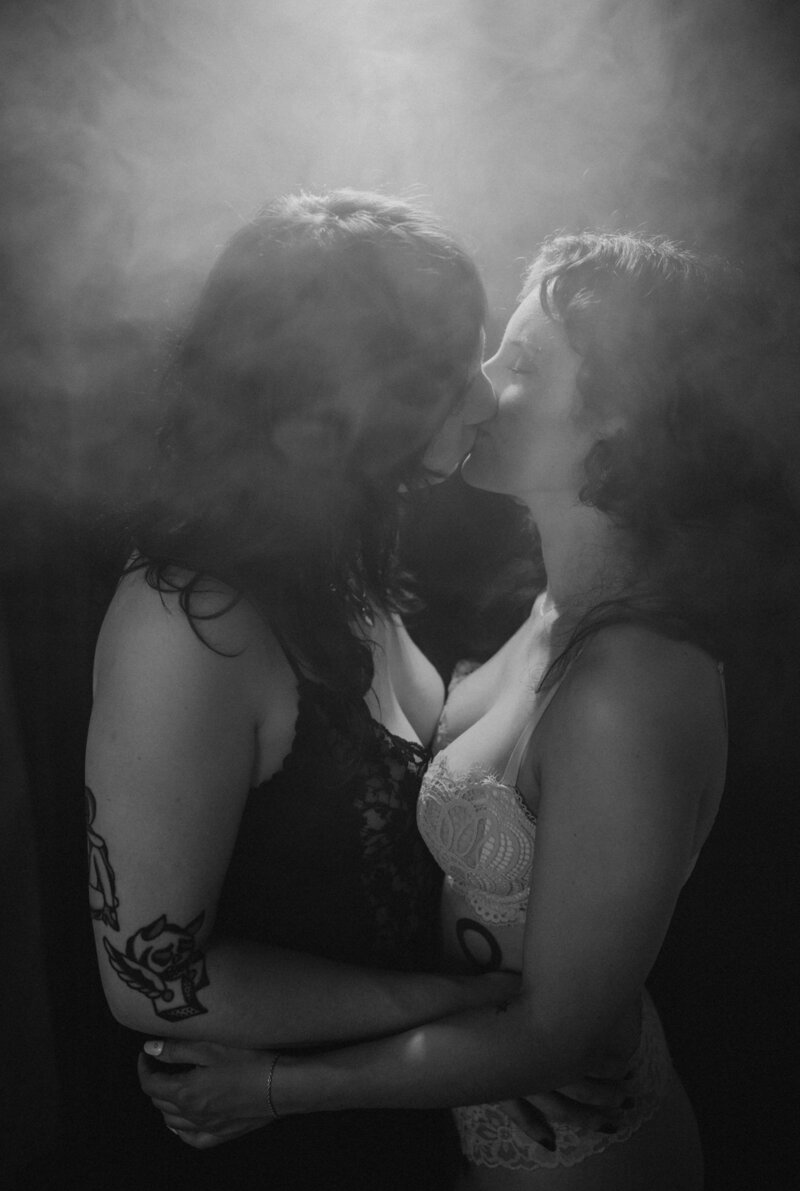 A couple in lingerie kissing with smoke around them 