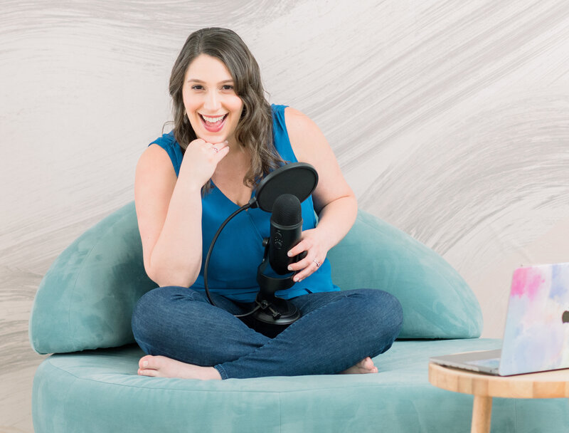 Isabel Kateman sitting on a couch with a podcast microphone and her laptop