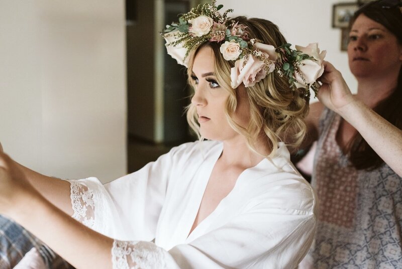 Wedding Designer putting flower crown on the bride