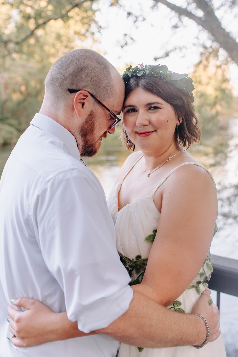 A couple leans in with their foreheads touching