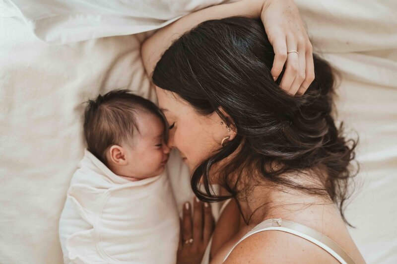 Two newborn twins in a basket, sleeping soundly in this newborn photoshoot shot by Kristin Wieskamp, a Pennsylvania photographer who specializes in maternity, family, and newborn photography.
