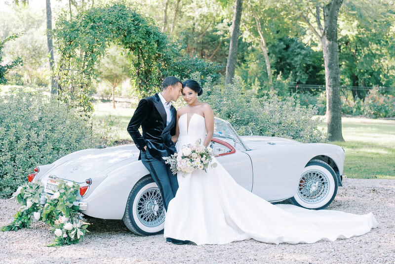 couple standing in front of car on wedding day