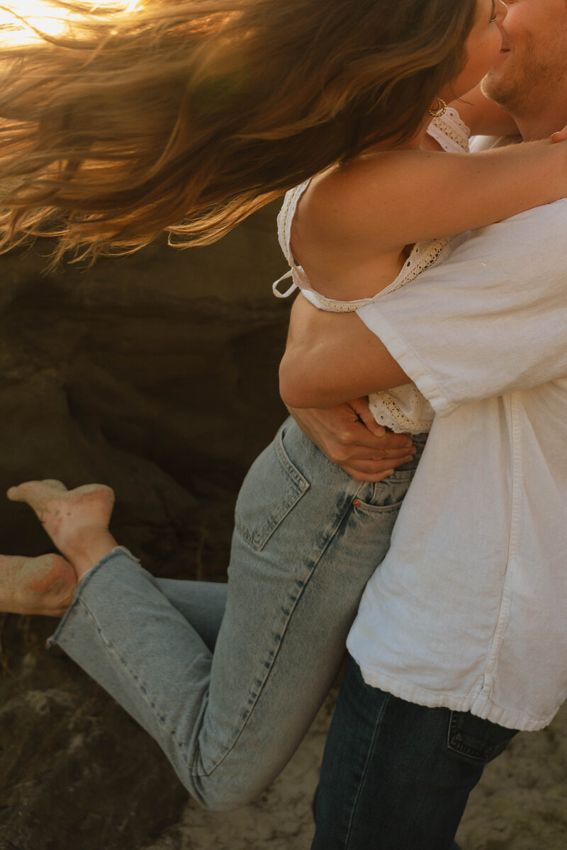 a man picking up a woman and spinning her in a circle
