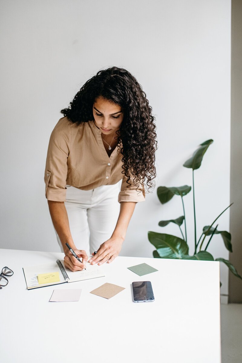 A woman writing on a notebook