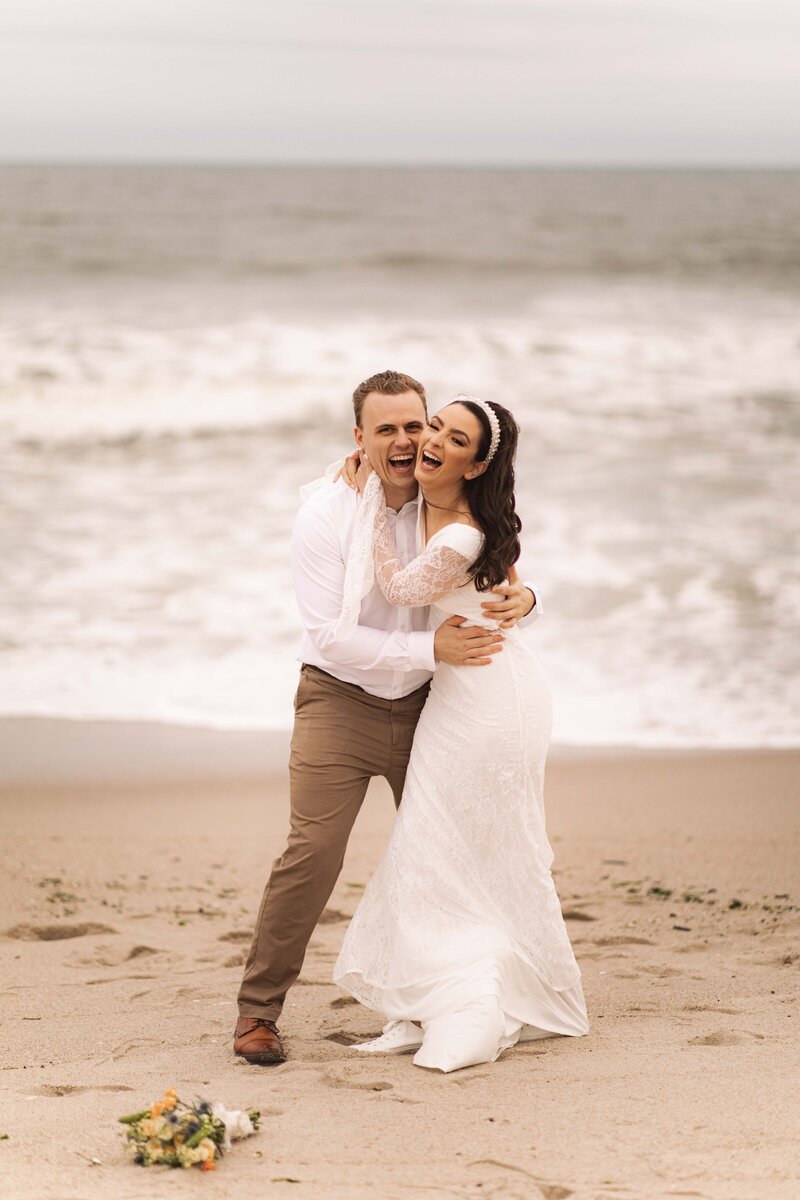 Married couple posing on their beach after their intimate wedding