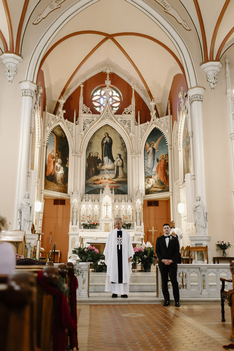 A GROOM AND PRIEST AT HOLY CROSS CHURCH CINCINNATI