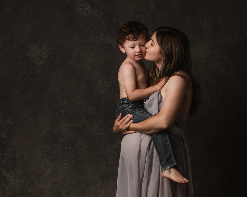 Fine art photo of pregnant mother and son in sweet kiss and embrace in San Francisco East Bay Family Photography Studio