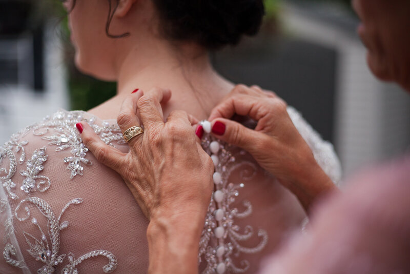 Detail image of bride's dress being buttoned