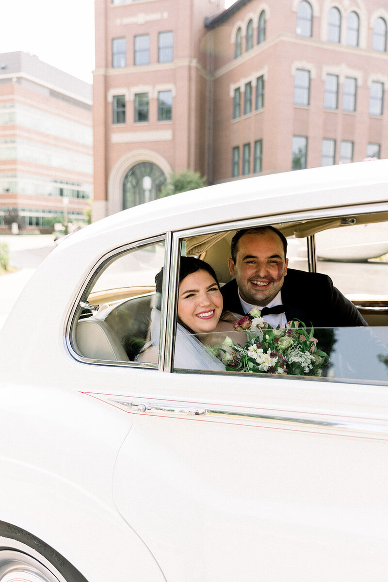 bride and groom inside of classic wedding car