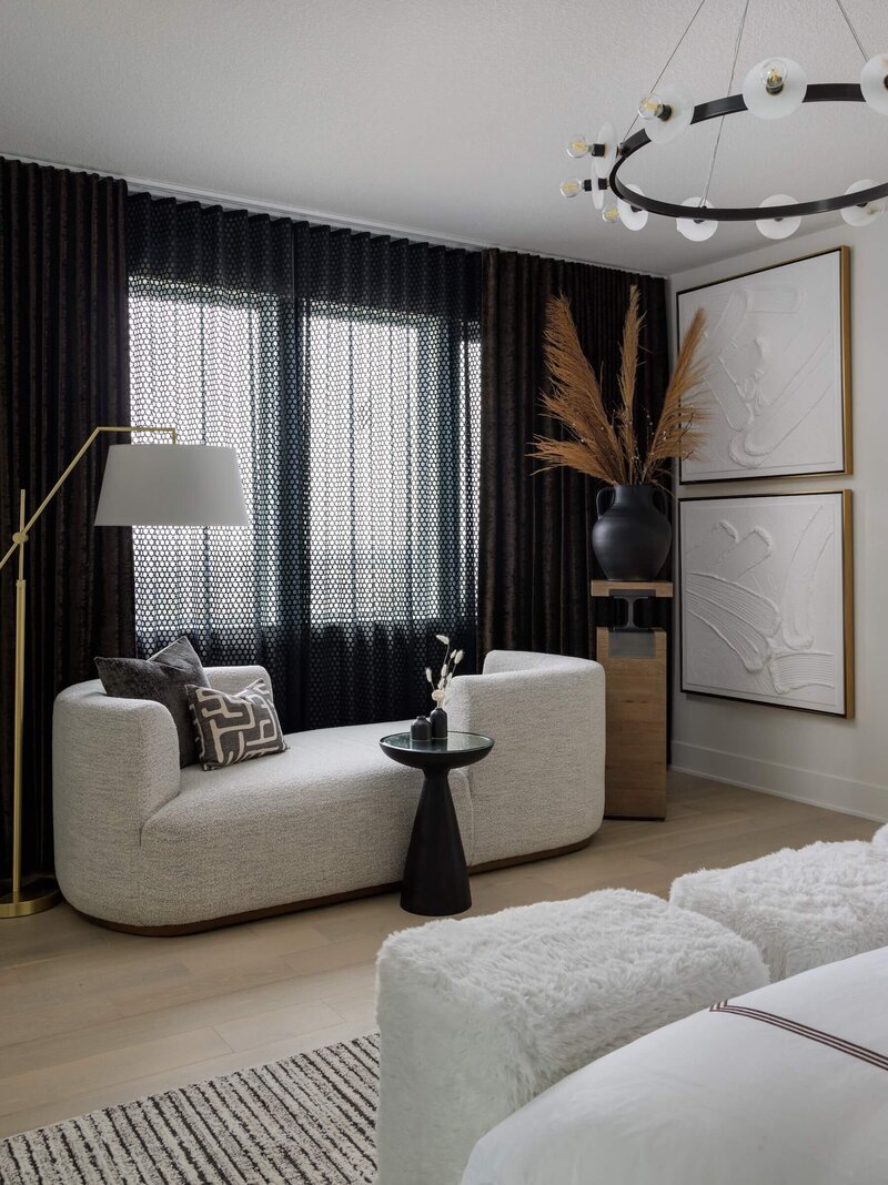 A reading corner in a primary bedroom with a custom chaise and floor lamp with oversized abstract textural artwork. 