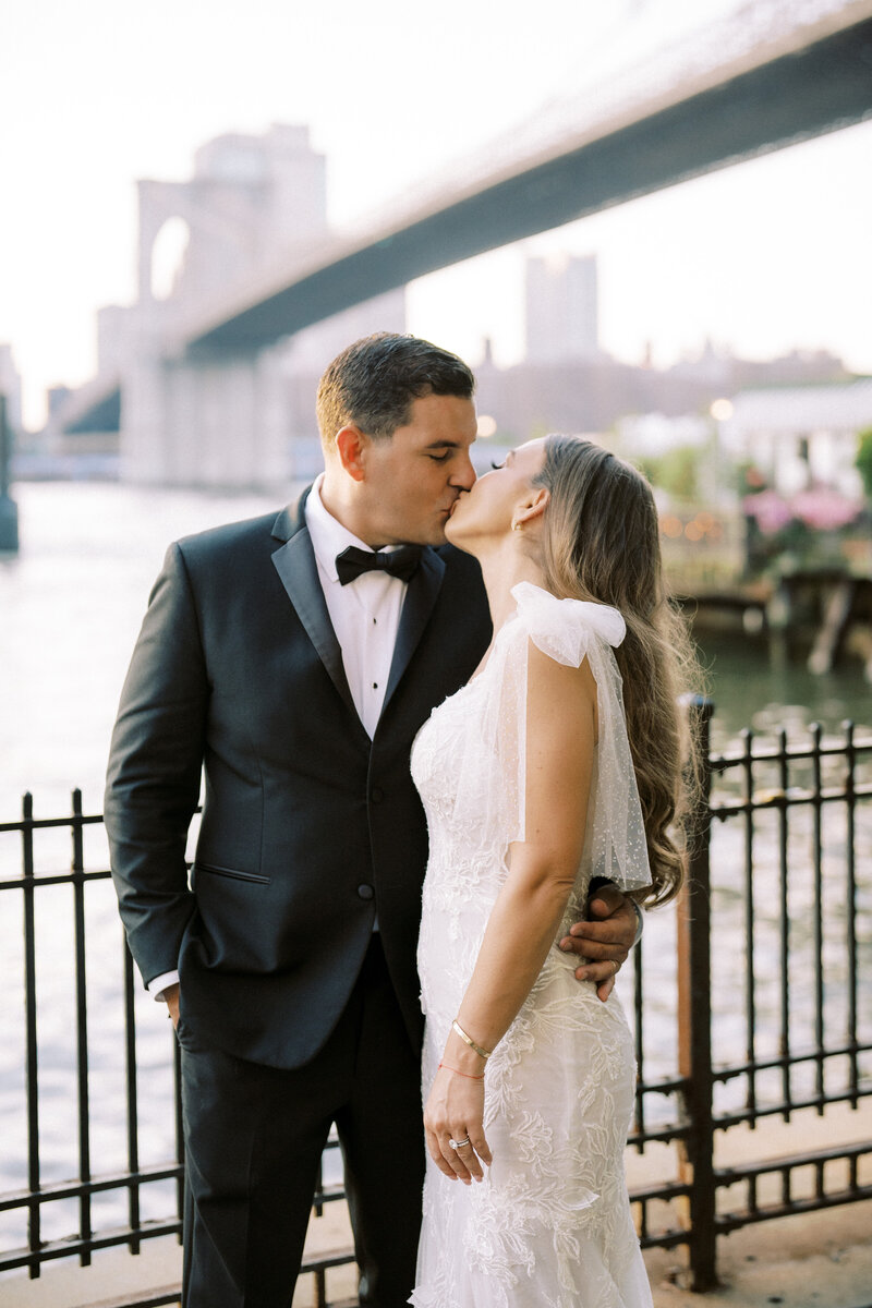 Candid Bride and Groom kissing in front of beach elopement