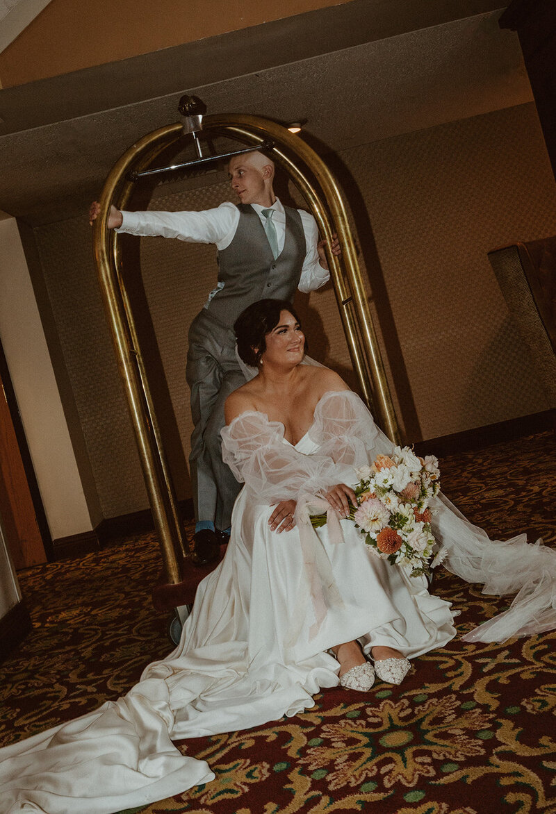 bride and groom pose in a hotel bellhop 