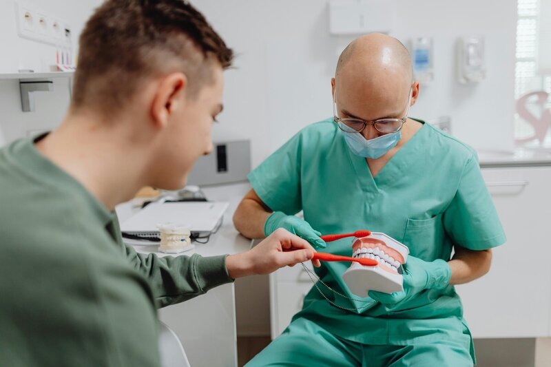 A dentist and patient reviewing how to properly brush your teeth 