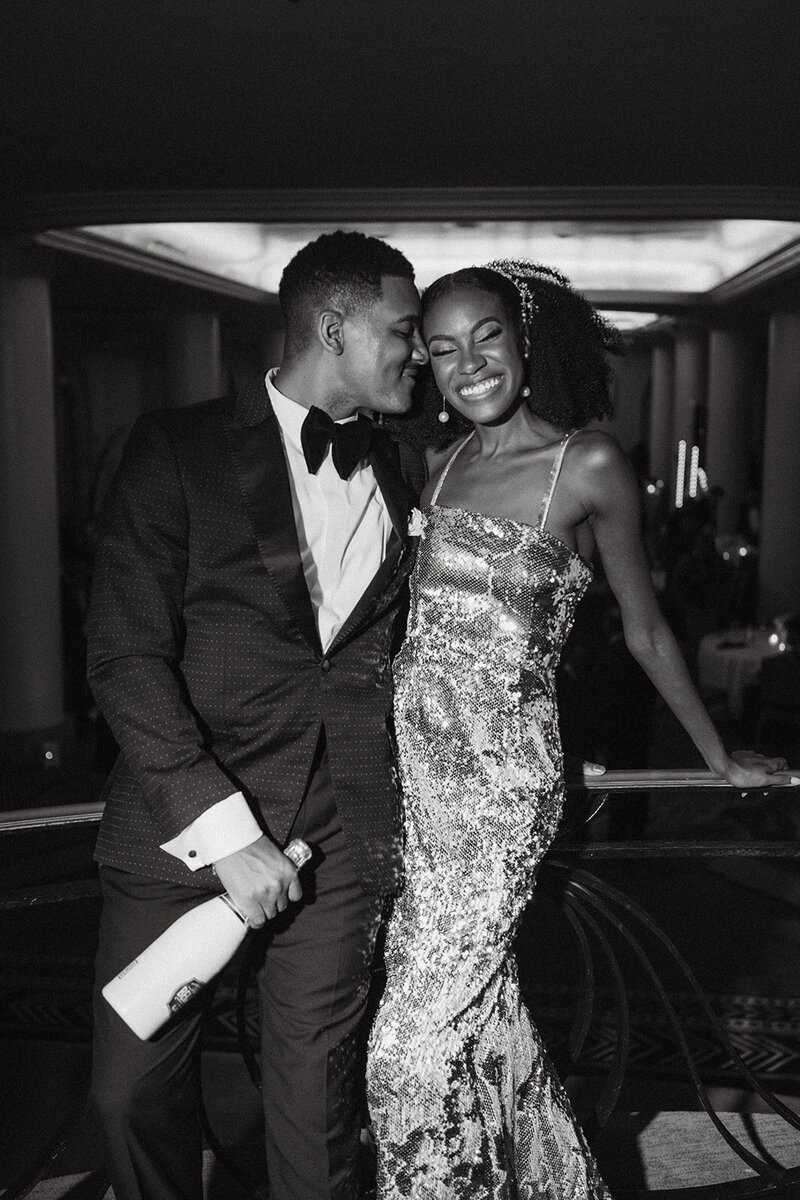 happy black couple smiling holding champagne 