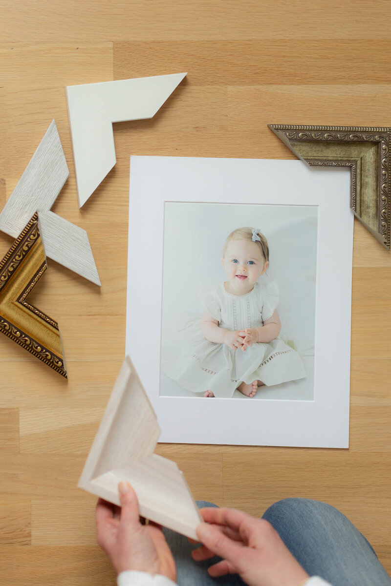 a photographer choosing a frame for a print of a client