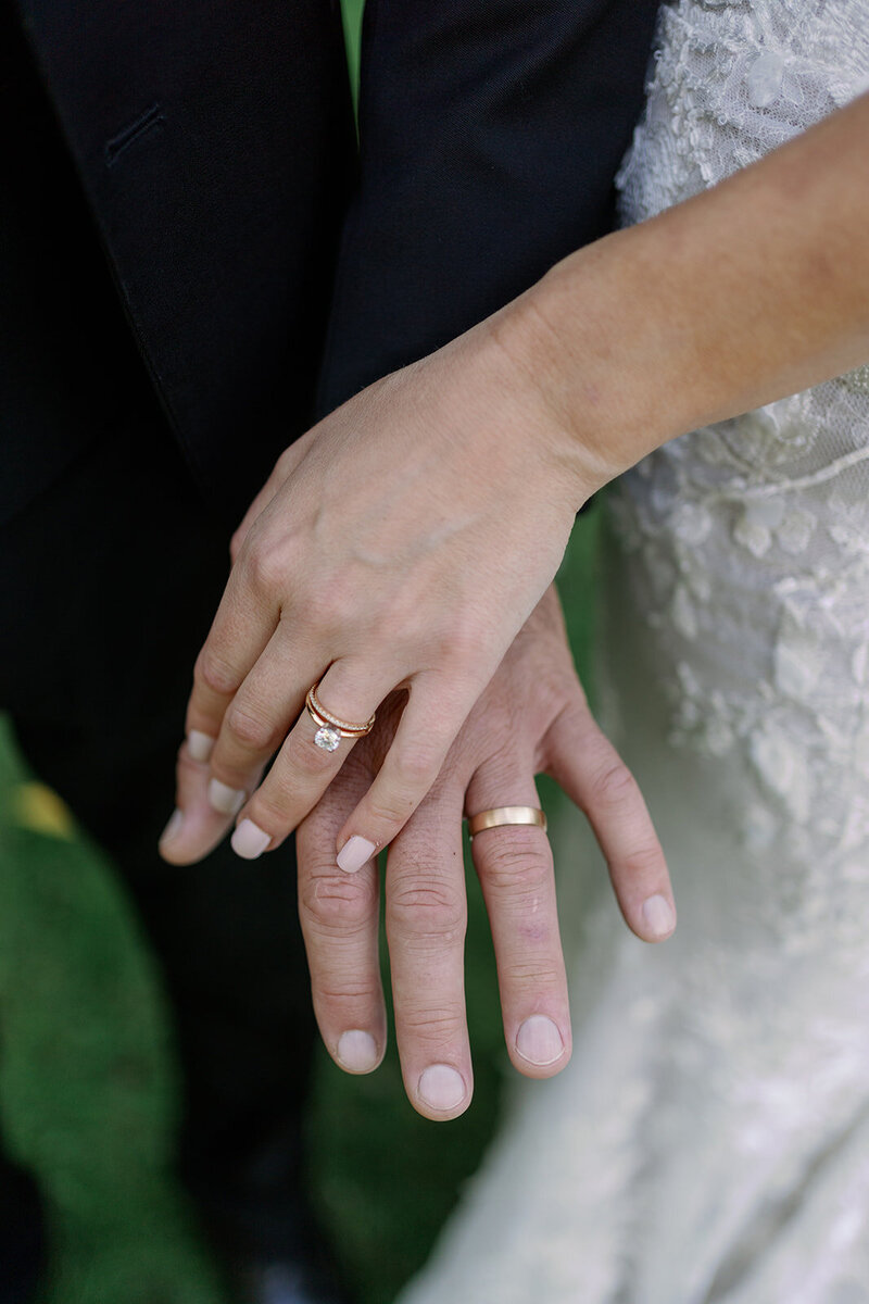 Close-up of the bride and groom’s hands showing their wedding rings during their intimate greenhouse wedding at Glasshouse Community.