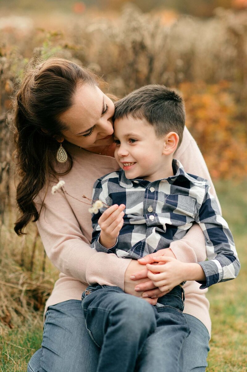 Maine Photographers share mother and son snuggling in a field