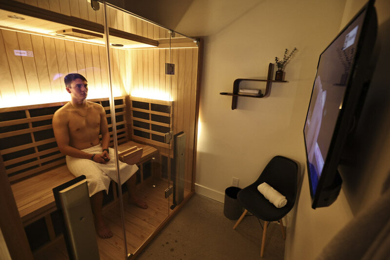 Man in a towel sitting in an Infrared sauna suite
