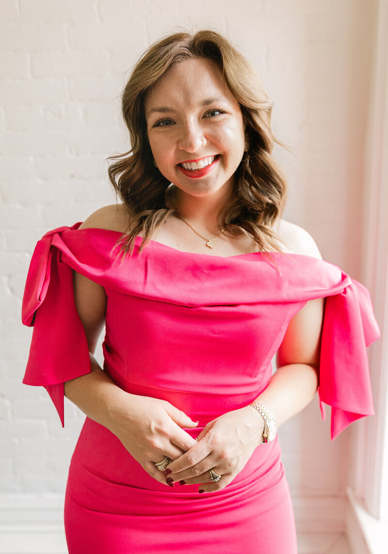 Colorado wedding photographer Logan Ferree smiling in a bright pink dress during studio brand portraits — Mrs. Ferree Photography.