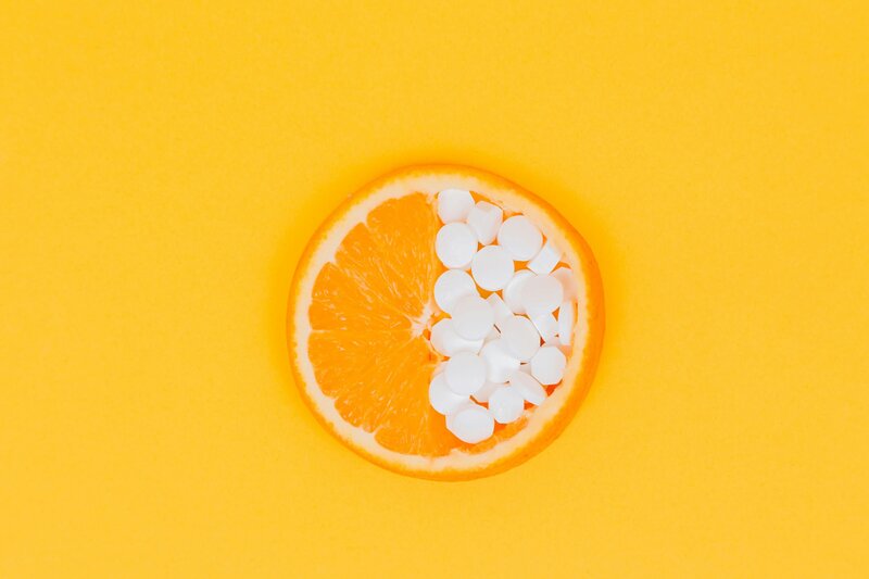 Slided orange with pills on one side on an orange background