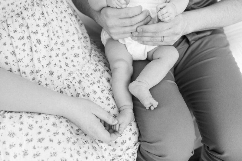 Black and white portrait of a mom holding her baby's foot