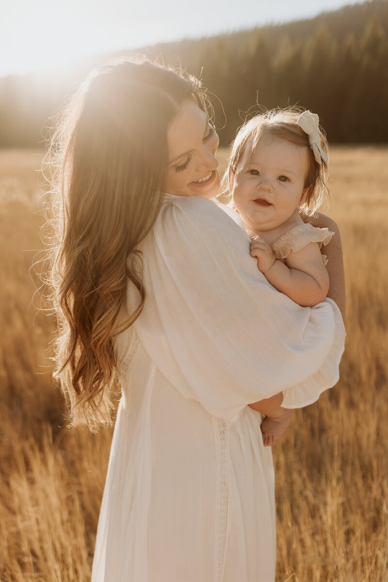 A mom with a baby in soft neutral colors