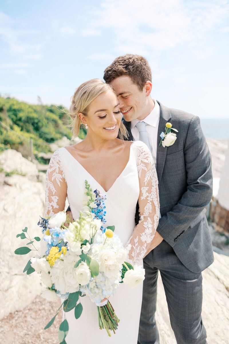 Groom lifting bride in the air with city skyline in the background