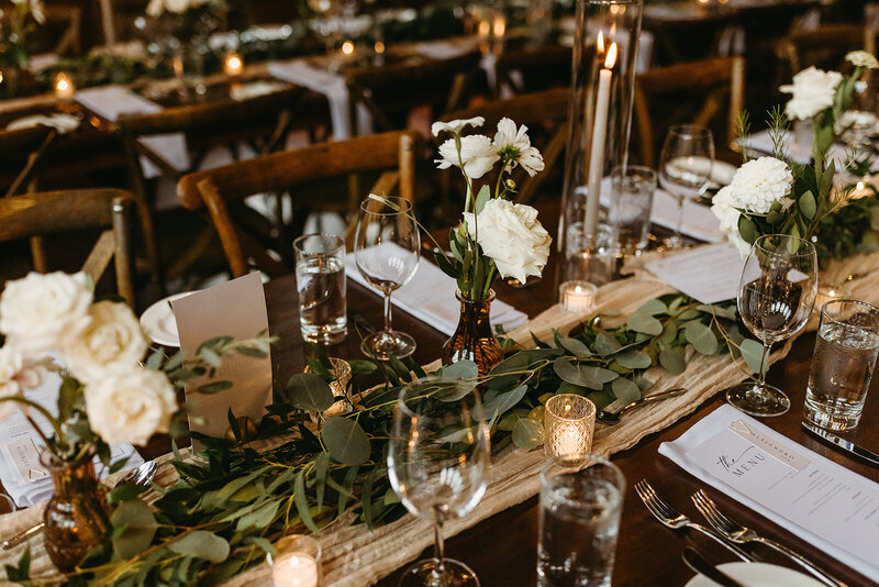 Rustic wedding tablescape with white florals, eucalyptus and white taper candles. 