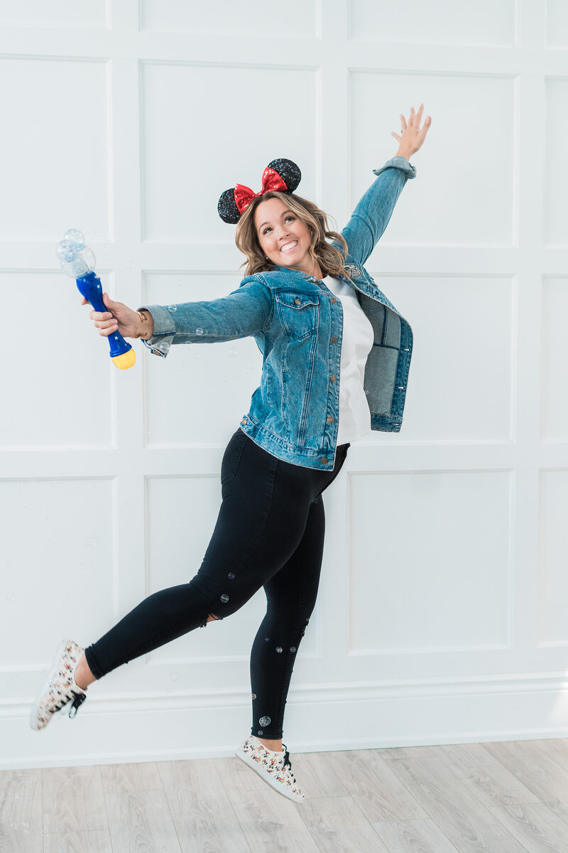 Jess Collins jumping with Mickey mouse ears on