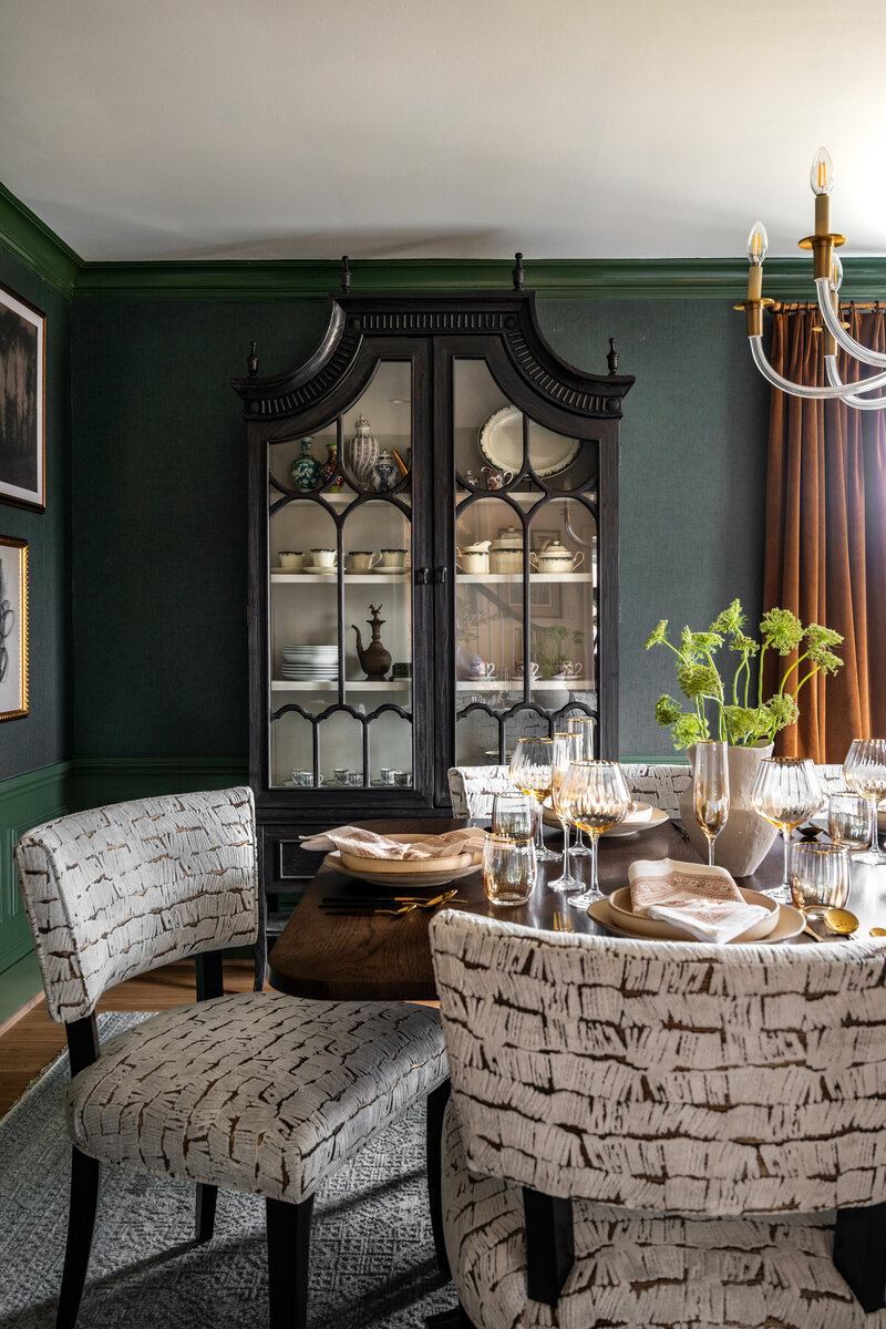 Styled corner cabinet with green walls and bold curtains