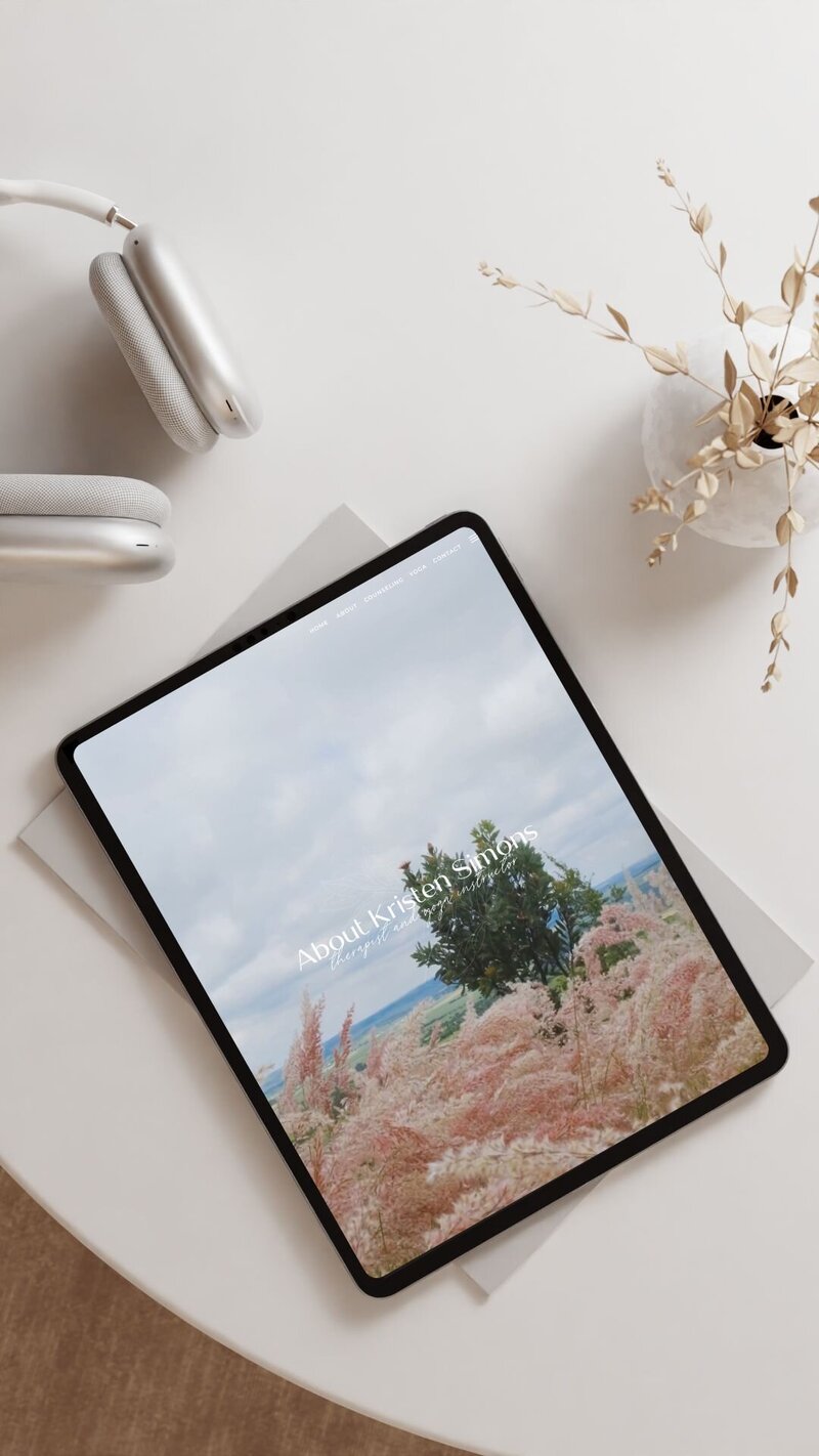 iPad sitting on a clean desk displaying a therapist website design in a inviting image.