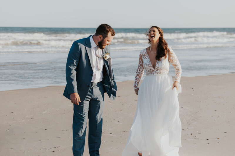 bride and groom laughing on beach