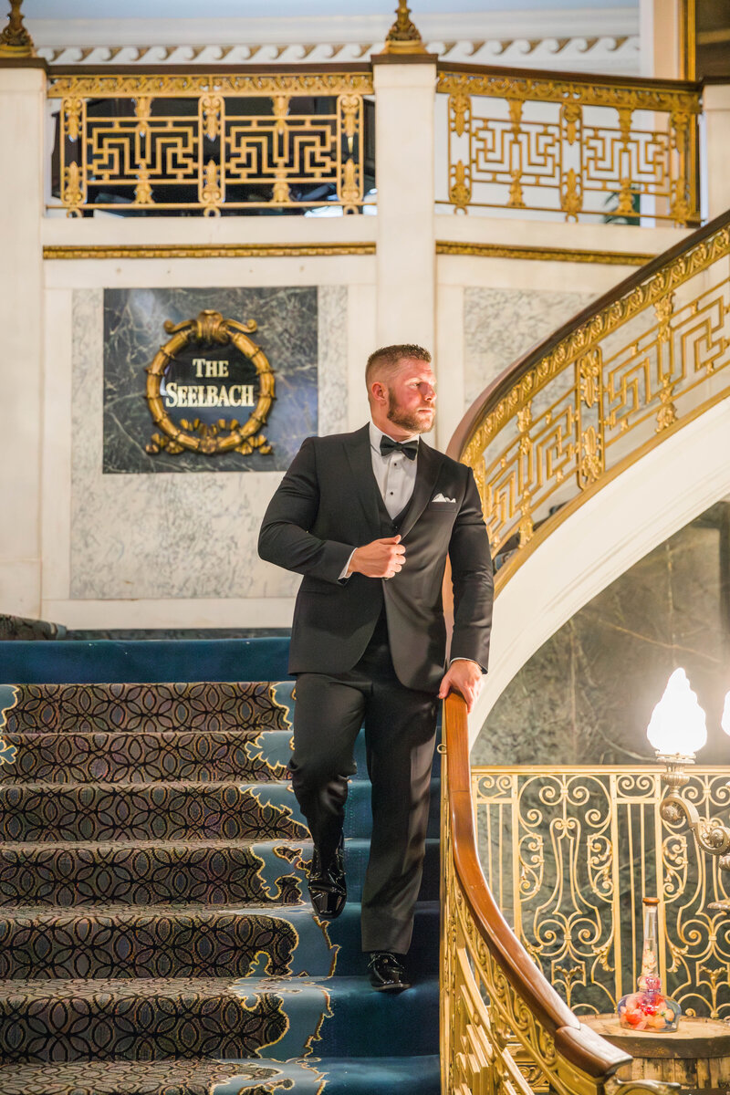 groom standing on stairs in a hotel for wedding portraits
