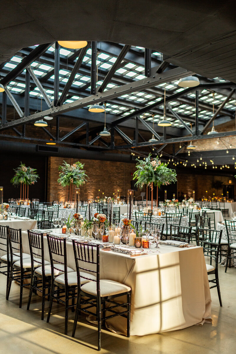 Beautifully decorated wedding reception tables with greenery and candles