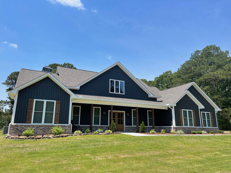 Dark blue newly built home with white trim.