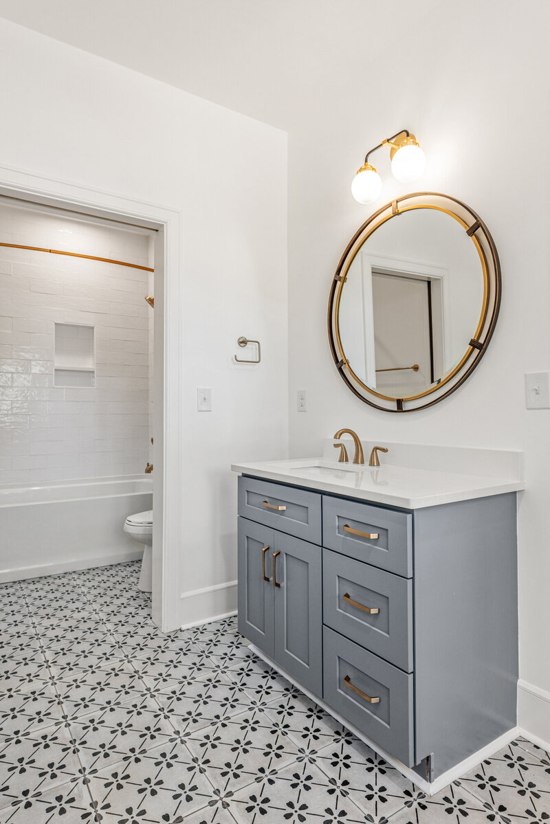 guest bathroom with custom tile and grey cabinets