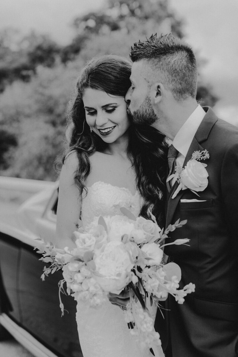 Groom kissing Bride's cheek