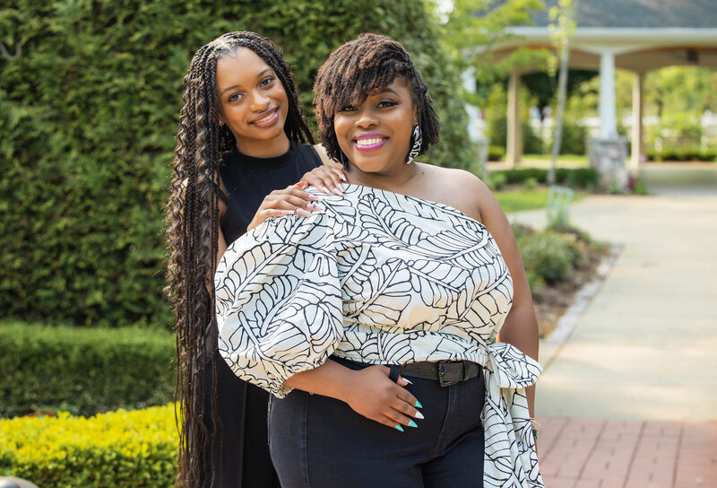 Mother and senior daughter wearing black and white posing together
