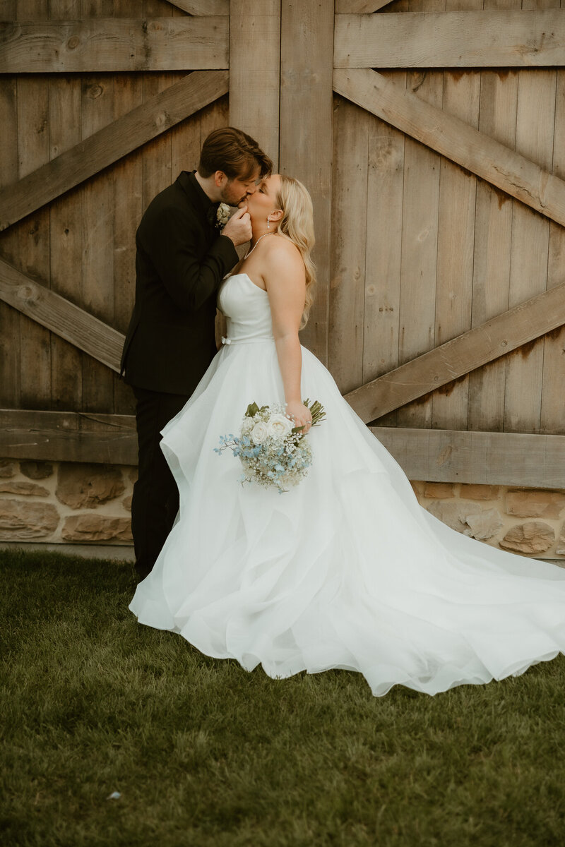 Couple share a kiss at their luxury wedding at Folino Estate in Kutztown PA 