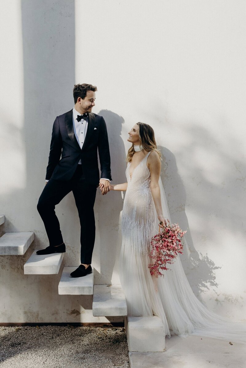 Tropical wedding in Merida, Mexico. Luxury couple portrait standing against a white wall