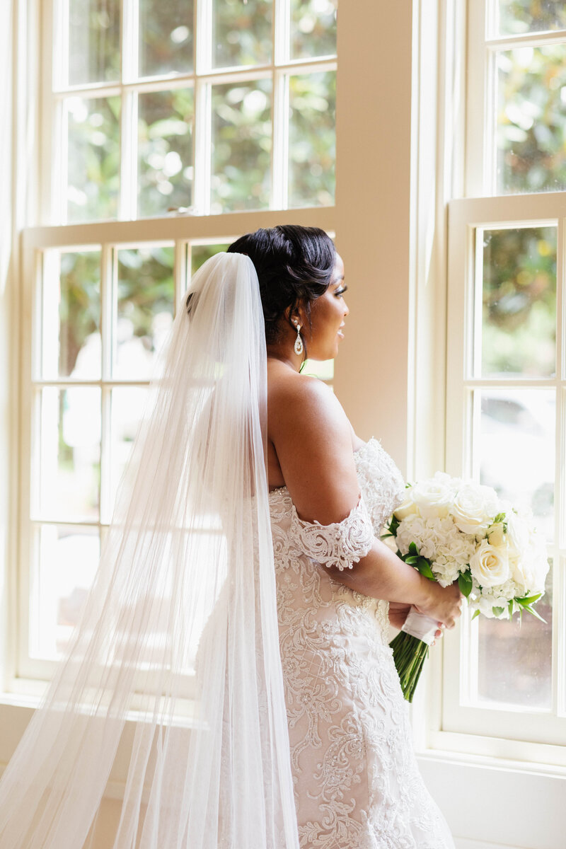 Candid photo of bride looking out the window at Agnes Scott College
