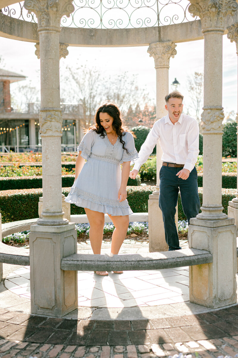 Greenville bride and groom outside Poinsett Hotel. The groom in a blue suit holding his bride wearing a short white dress with white heels.