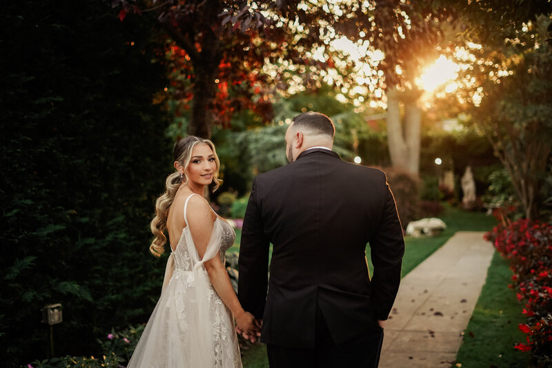 bride and groom walking away from camera at sunset