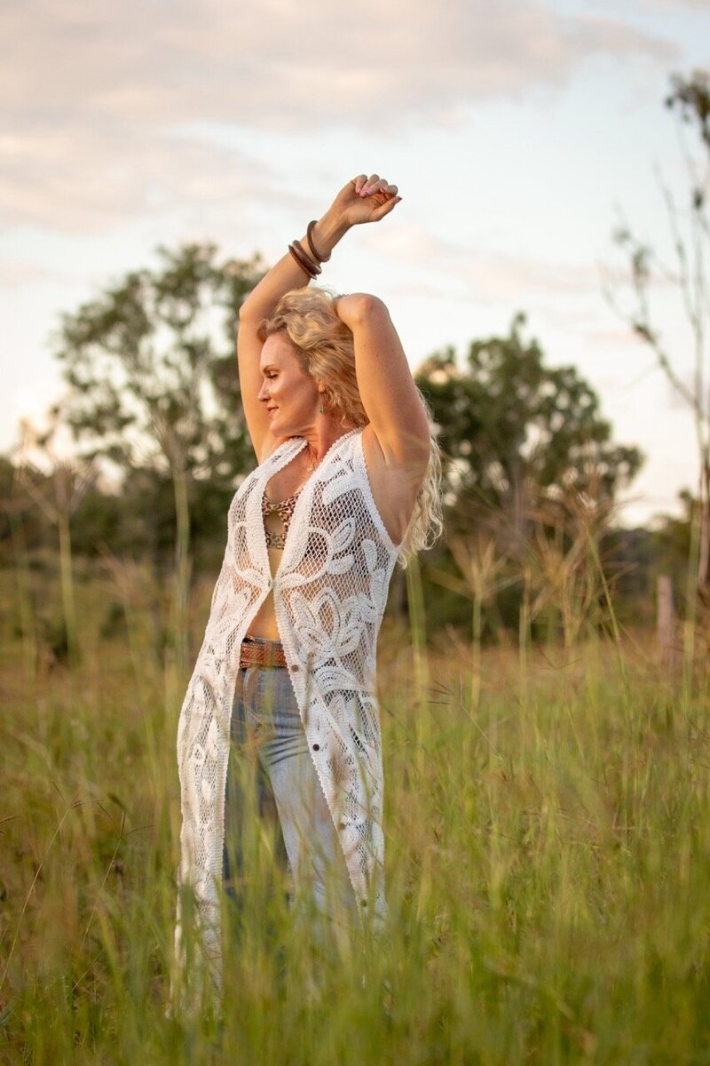 Sigrid Eliese, somatic mentor and coach guiding The Goddess Within Coaching Program, arms gently outstretched to sky 