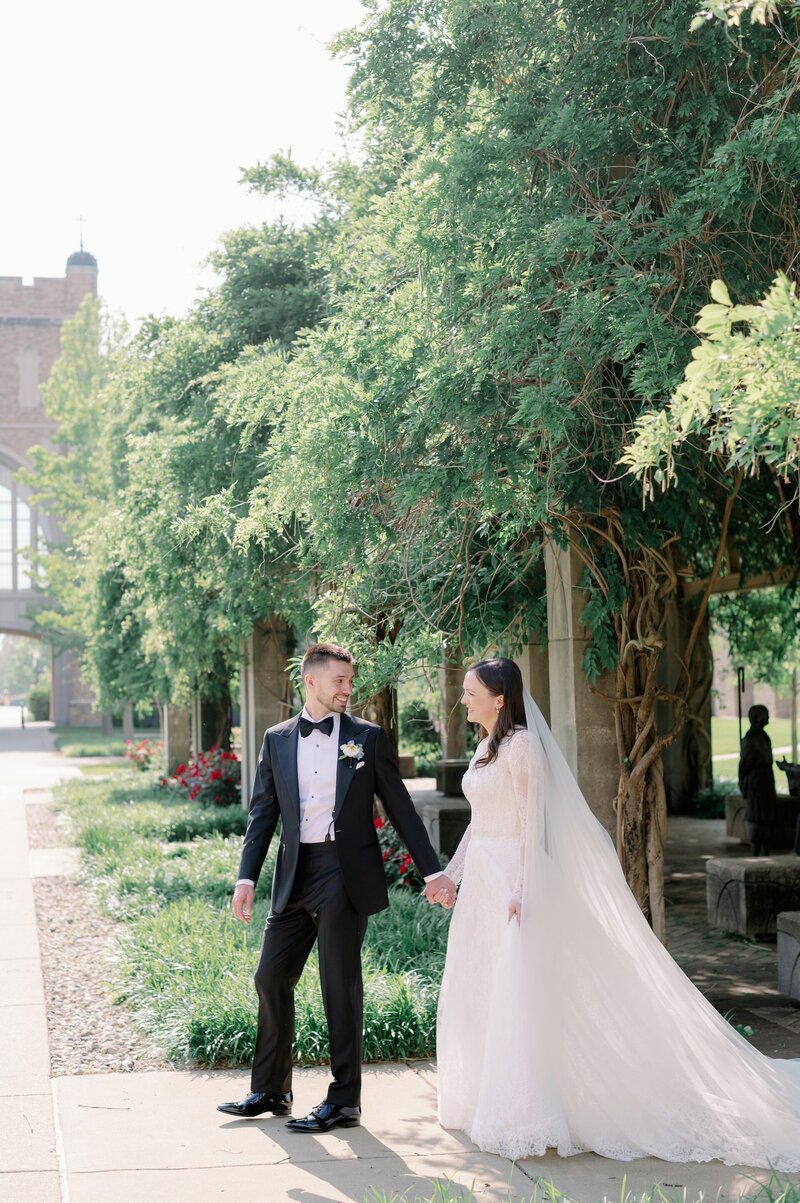 newlyweds walking on Notre Dame's campus on their wedding day