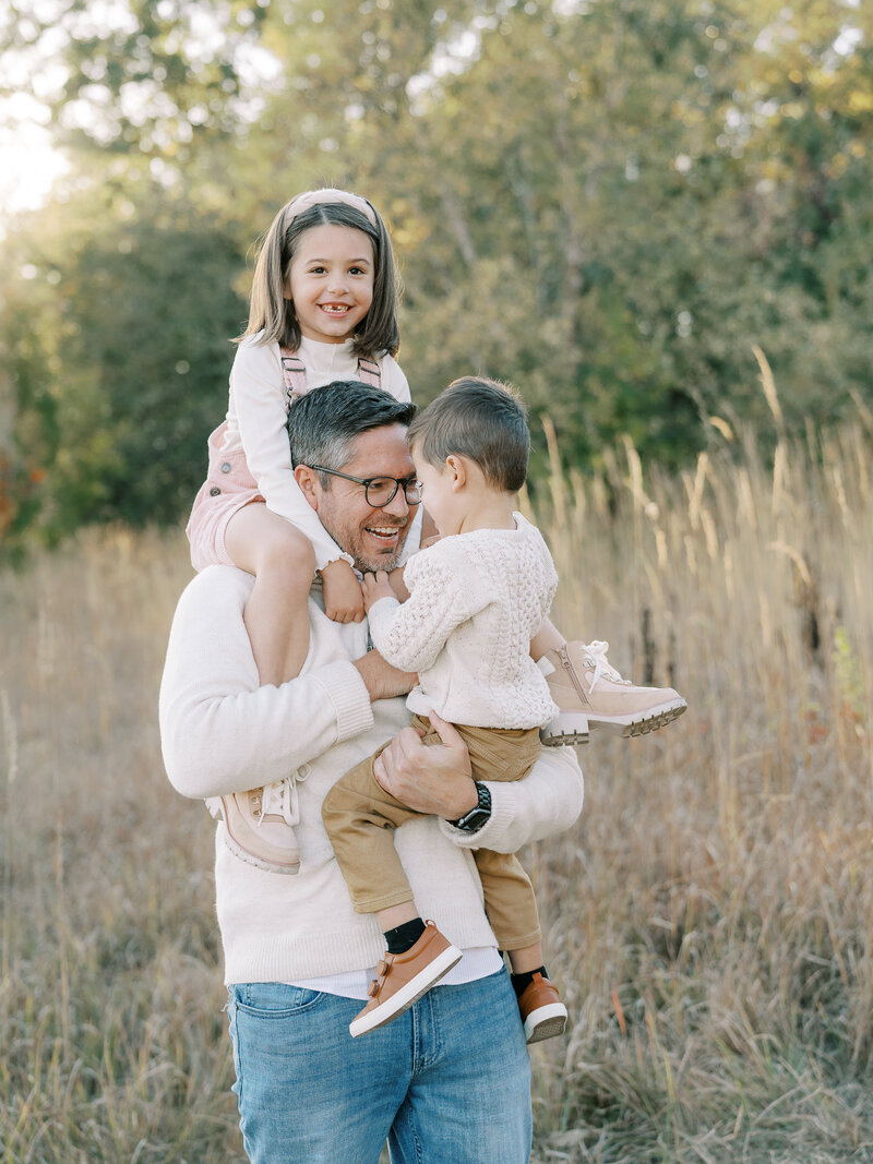 dad holding two kids during family photos
