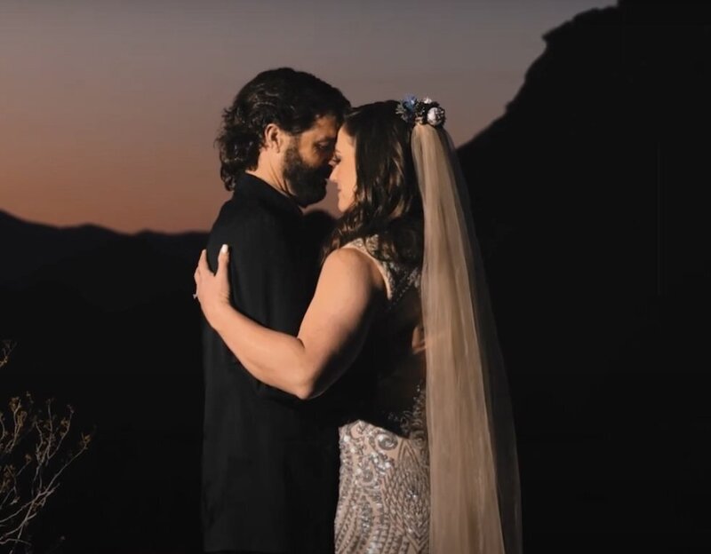 a newlywed couple standing forehead to forehead dancing 