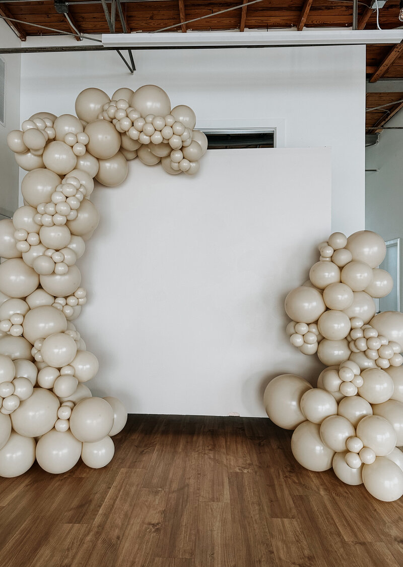 Organic and beige or tan balloon garland on white wall.