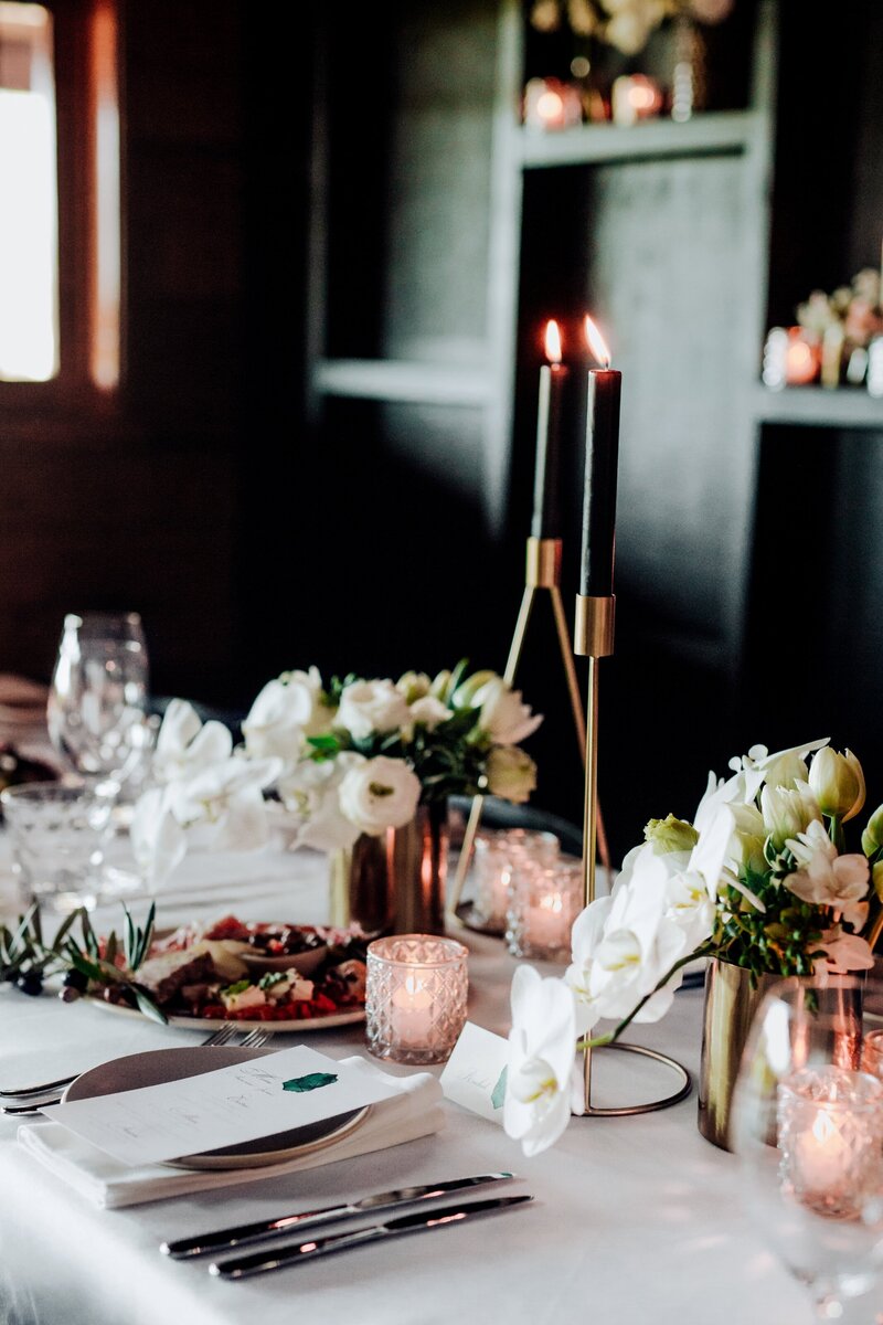Dark moody wedding reception with candles and black tableware